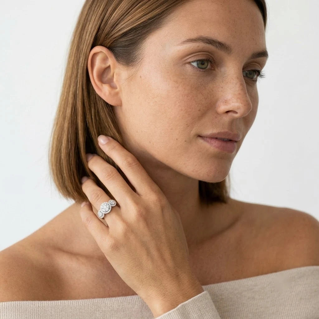 FineDiam three stone halo diamond ring featuring graduated round clusters and a slim white metal band.