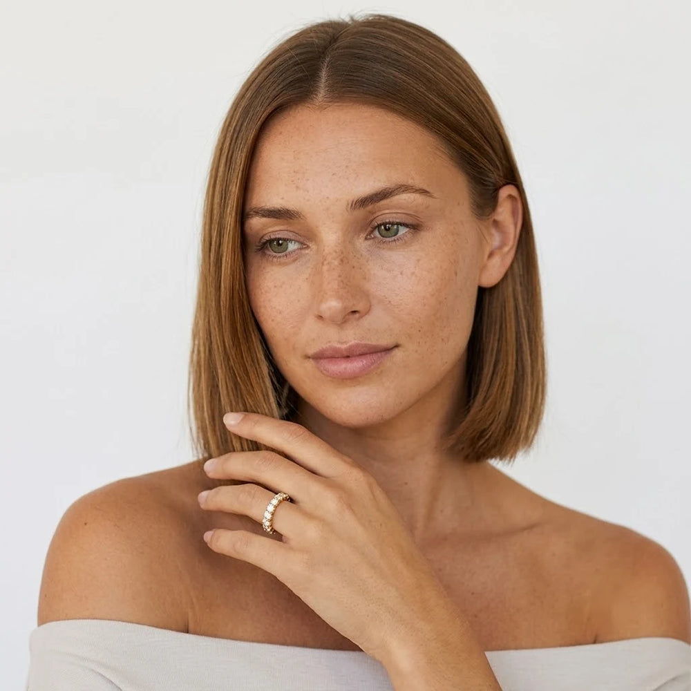 FineDiam yellow gold diamond ring with round cut stones arranged along a curved band.
