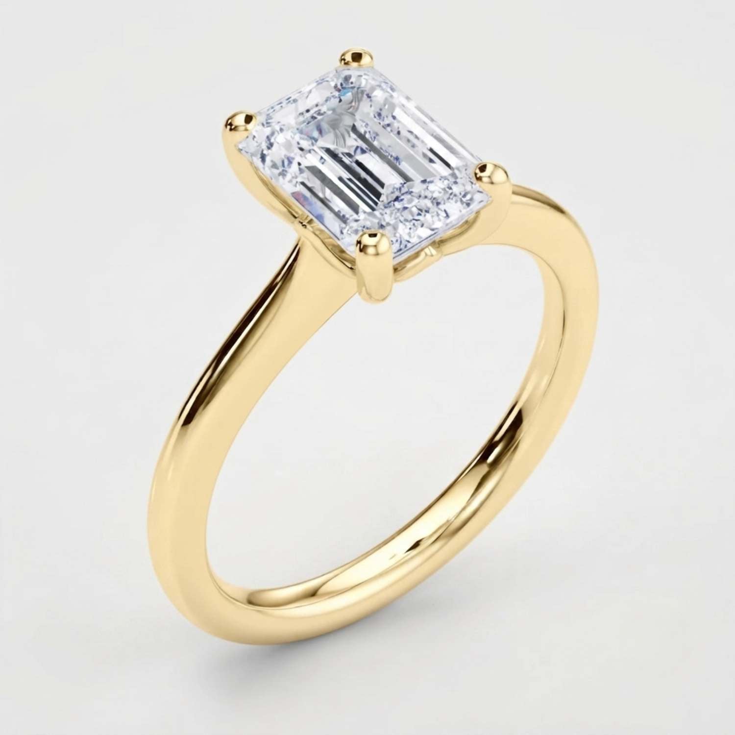 Angled perspective view of a handcrafted emerald-cut diamond solitaire ring in polished white gold.