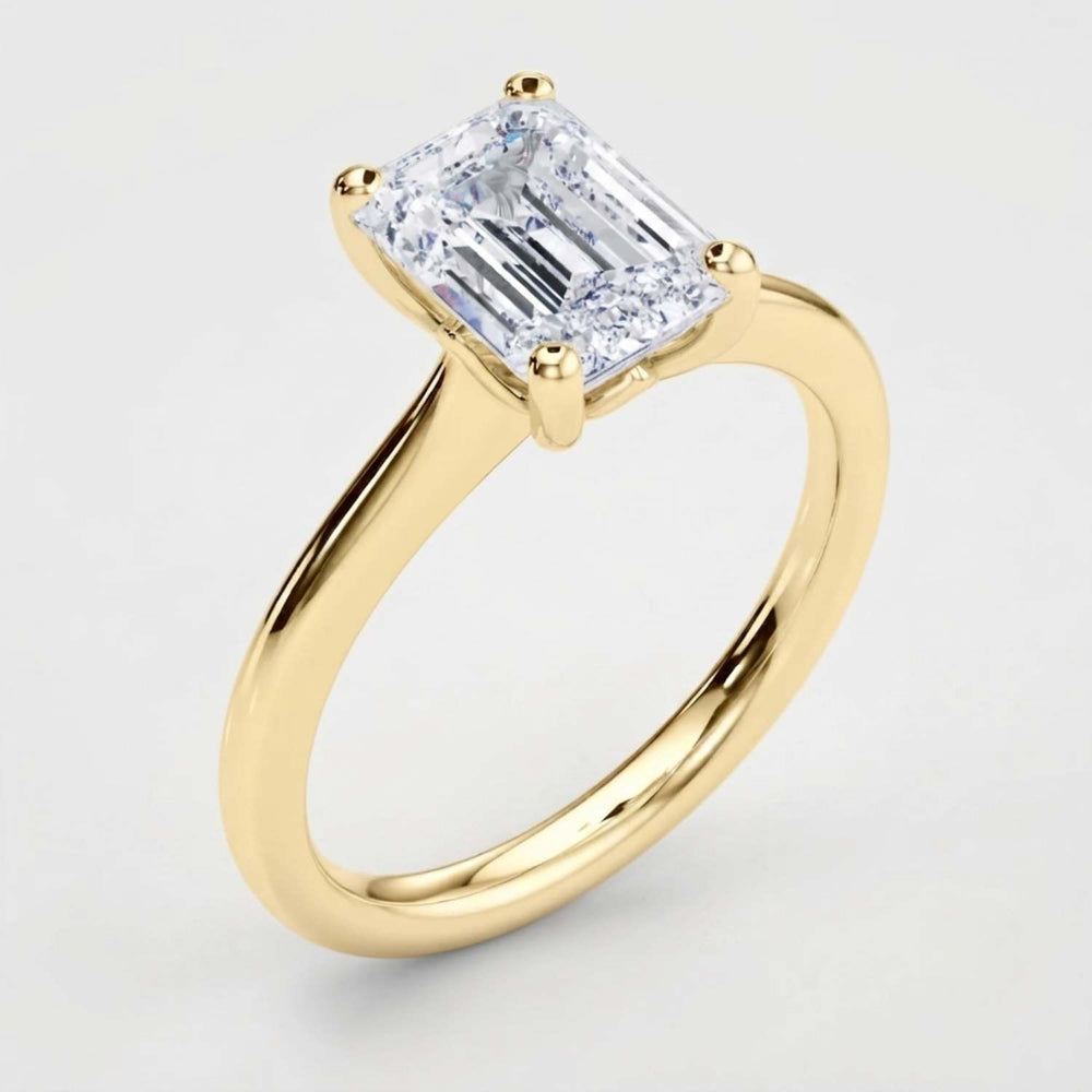 Angled perspective view of a handcrafted emerald-cut diamond solitaire ring in polished white gold.