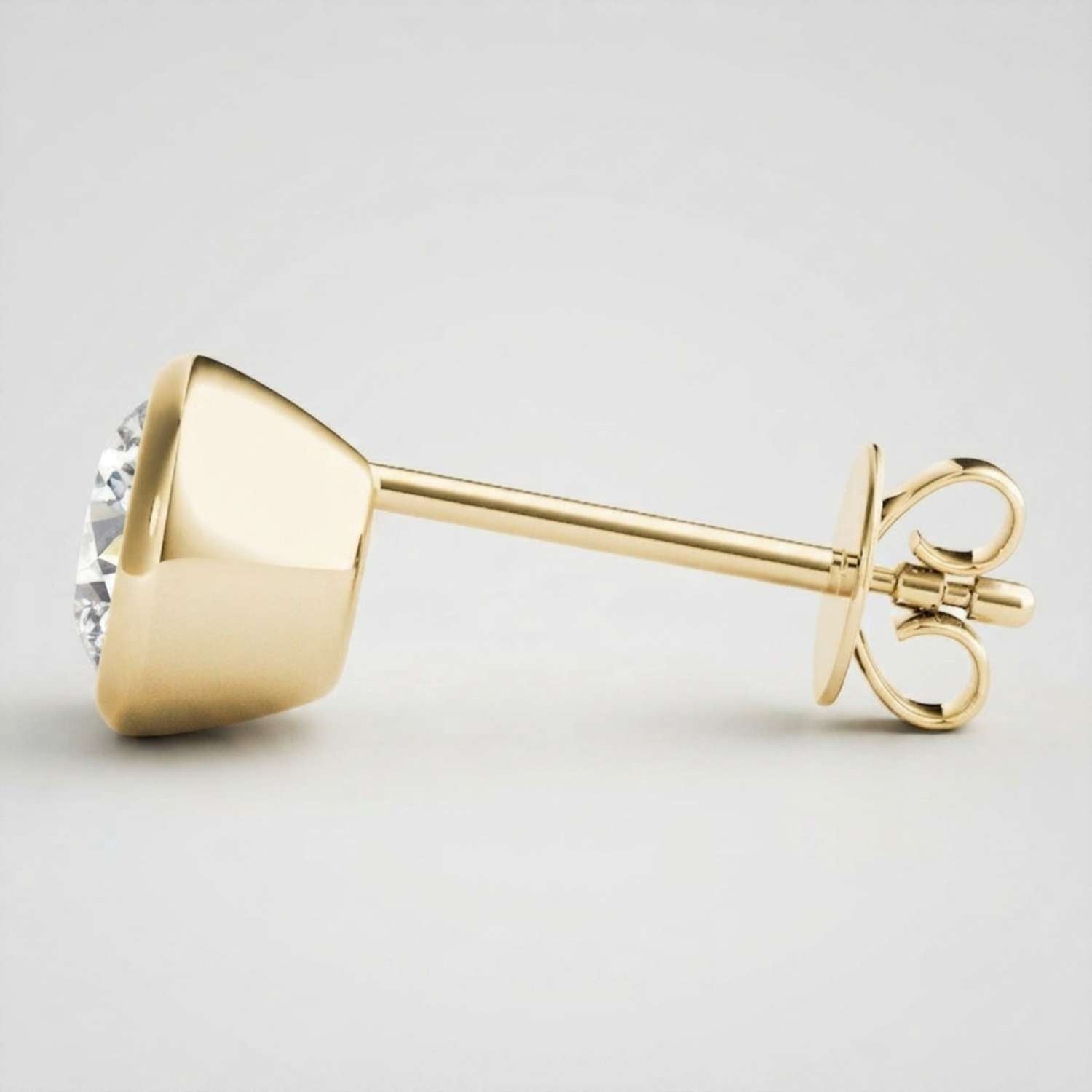 High-end solid gold bezel solitaire studs showcasing a bold, minimalist modern aesthetic.