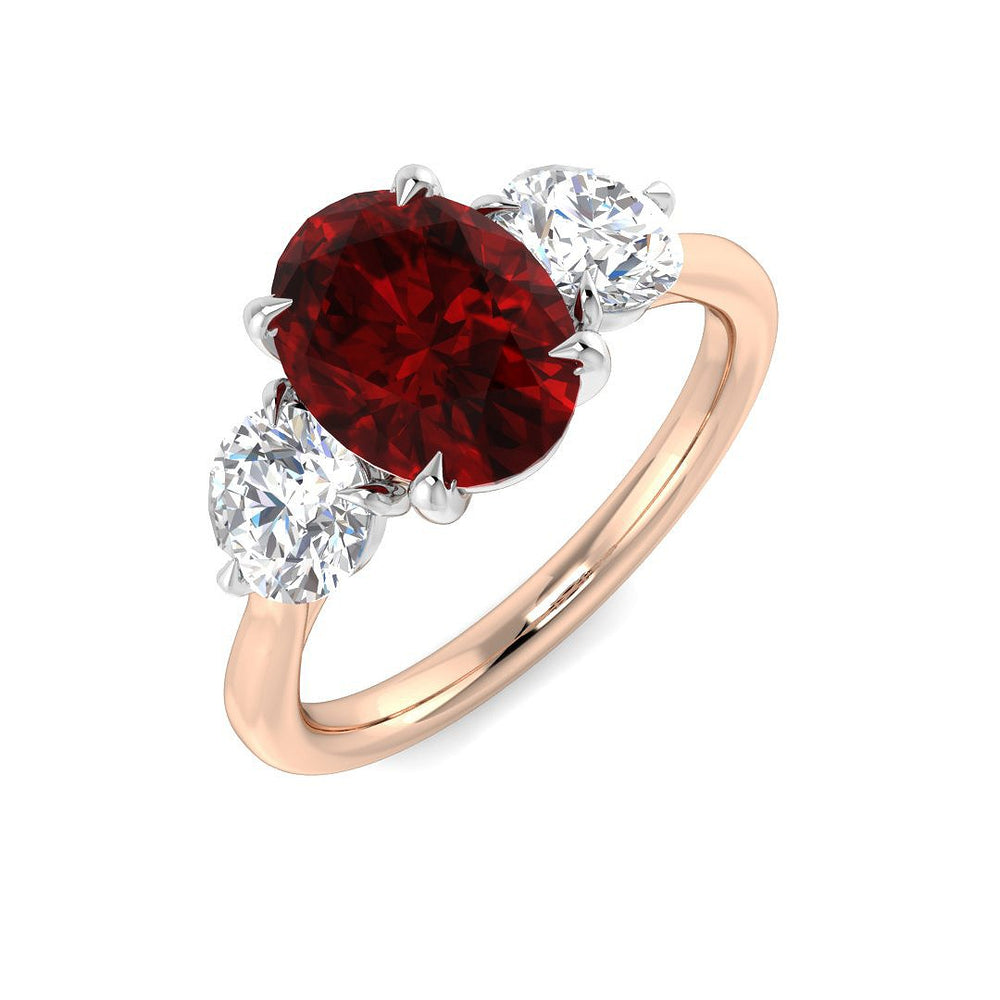 Ruby Three Stone Ring featuring an oval cut ruby center with diamond side stones in a rose gold setting.