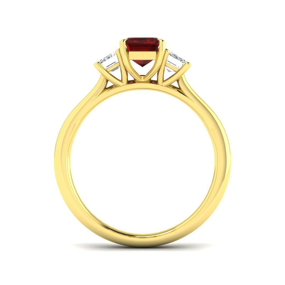 Ruby Three Stone Ring featuring emerald cut ruby centerpiece and diamond side stones in a gold setting.