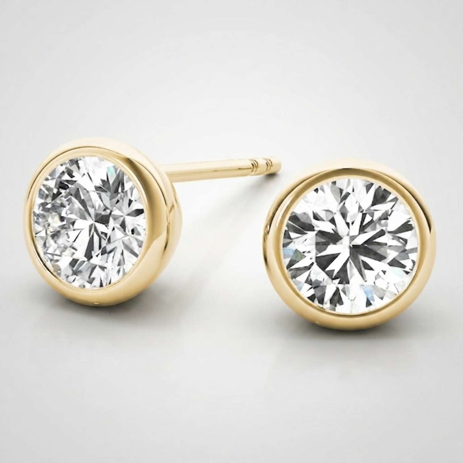 Side profile view of a low-profile bezel-set diamond stud earring highlighting the smooth metal rim.