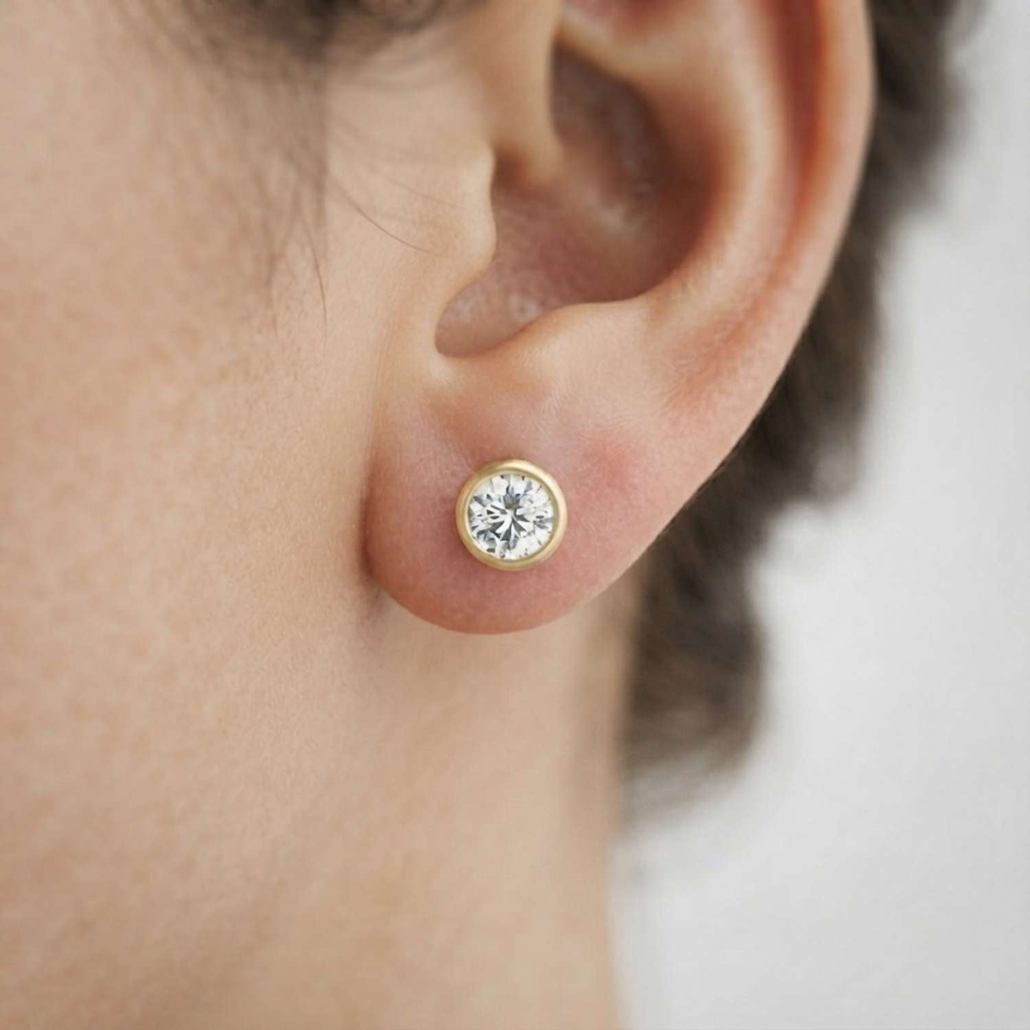 Pair of modern lab-grown diamond rub-over studs displayed cleanly for online jewelry retail.
