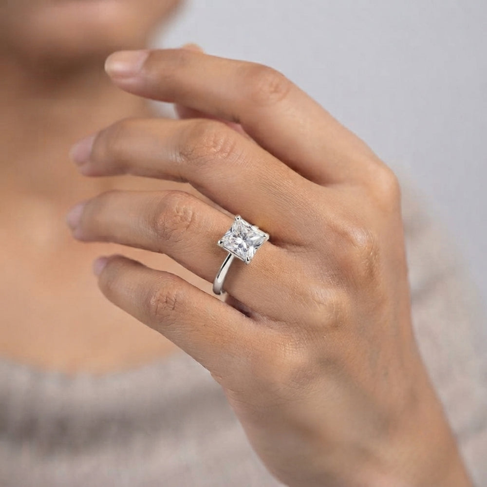 Side profile view of a platinum princess-cut solitaire engagement ring highlighting the prong setting.
