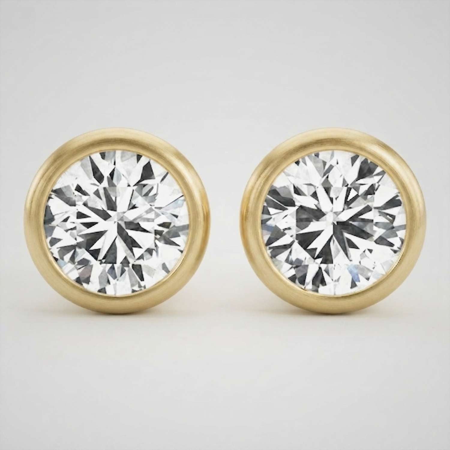 Elegant platinum round brilliant diamond stud earrings featuring a secure full bezel frame.