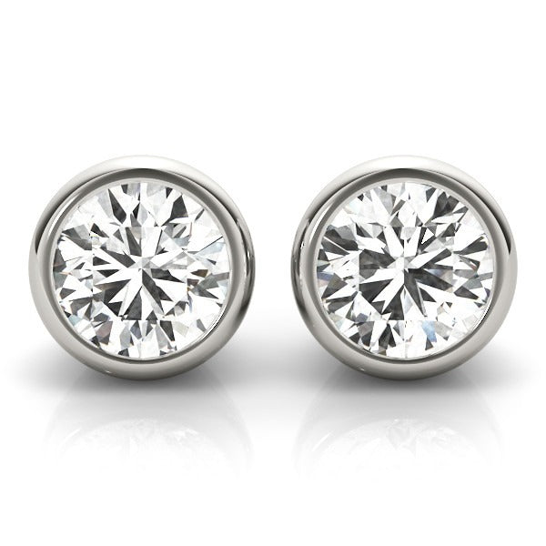 Close-up of bezel-set round lab-grown diamond stud earrings in yellow gold with push-back closures.