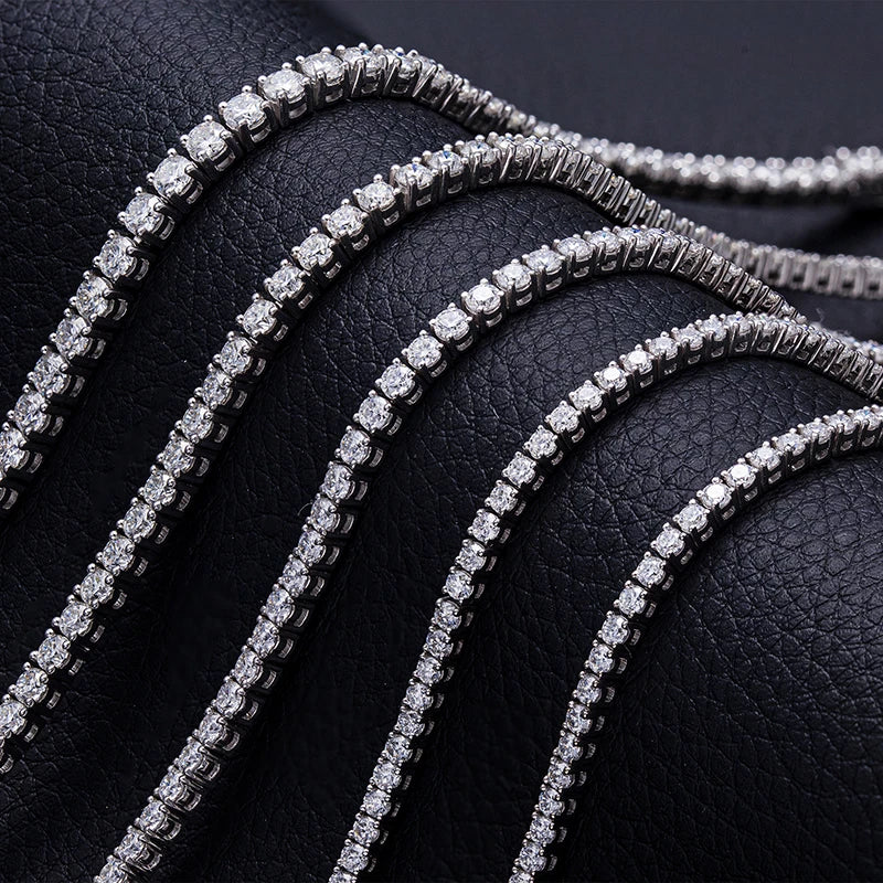 Diamond tennis bracelets on a black leather surface