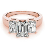 Rose gold ring with three emerald-cut diamonds on a white background