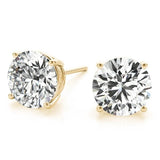 Gold stud earrings with large clear gemstones on a white background