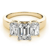 Gold ring with three emerald-cut diamonds on a white background