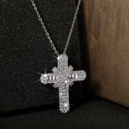 Silver cross necklace with clear stones on a dark background