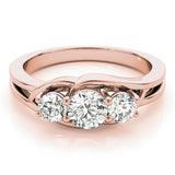 Rose gold ring with three diamonds on a white background