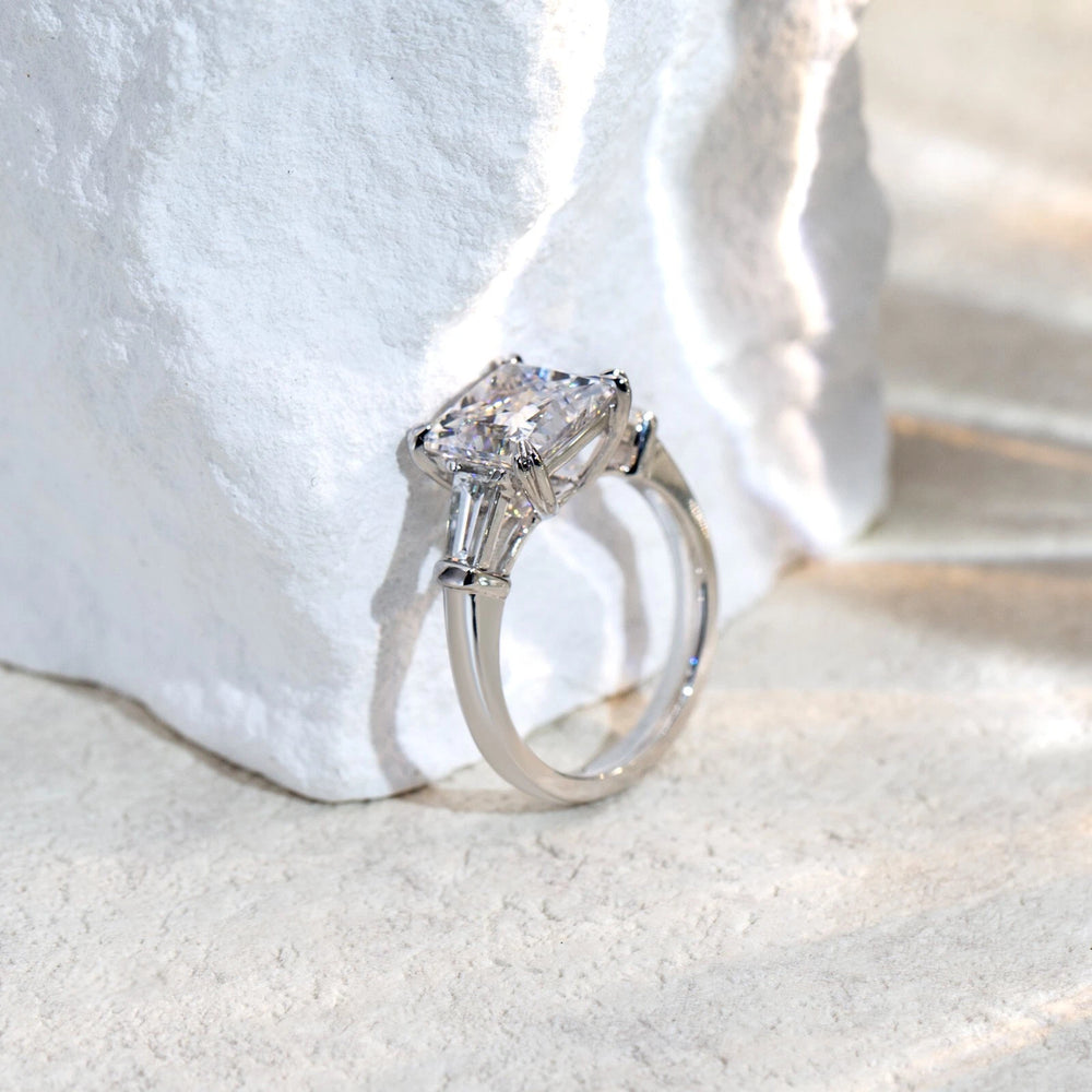 Silver ring with a large diamond on a white fabric background