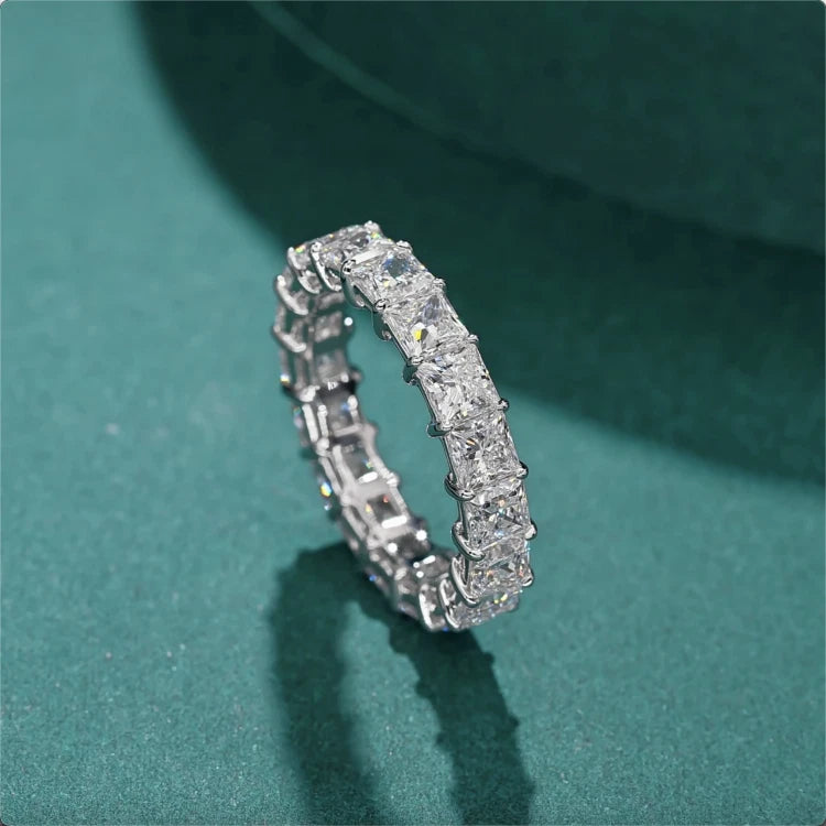 Silver ring with diamonds on a green background