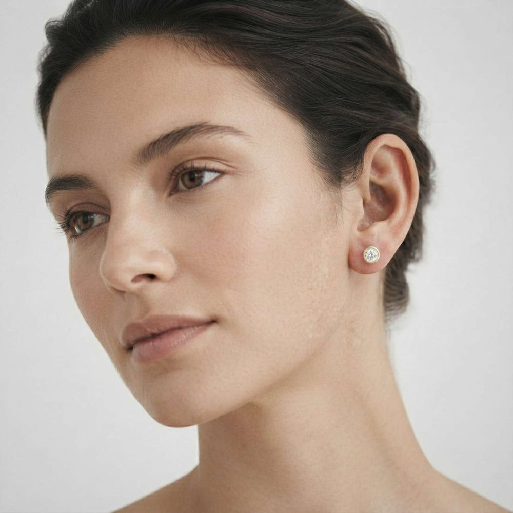 Classic round brilliant-cut diamond rub-over studs crafted for everyday luxury wear.