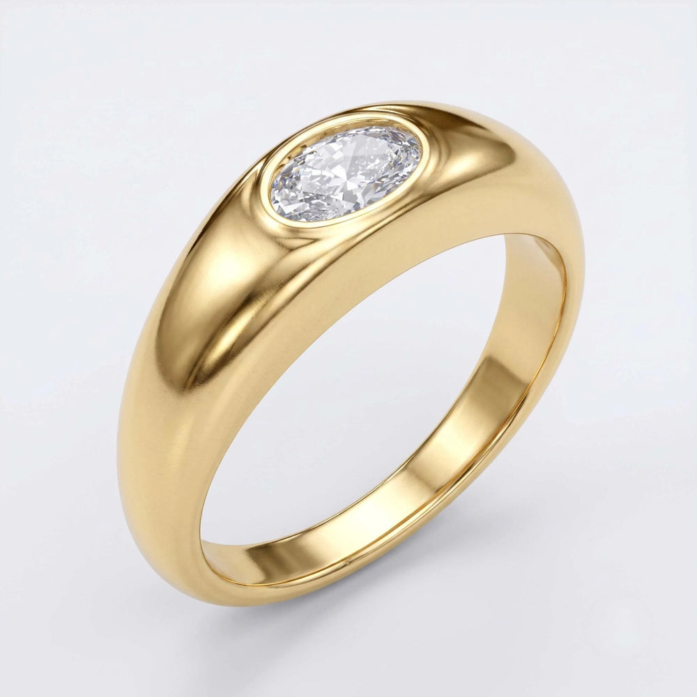 A polished yellow gold ring featuring an oval-cut clear gemstone in a bezel setting, shown on a clean light gray background.